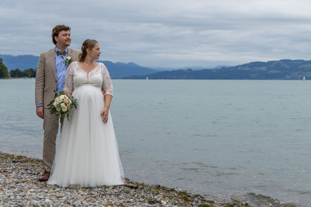 Selina und Matthias am Seeufer vor den Bergen am Bodensee